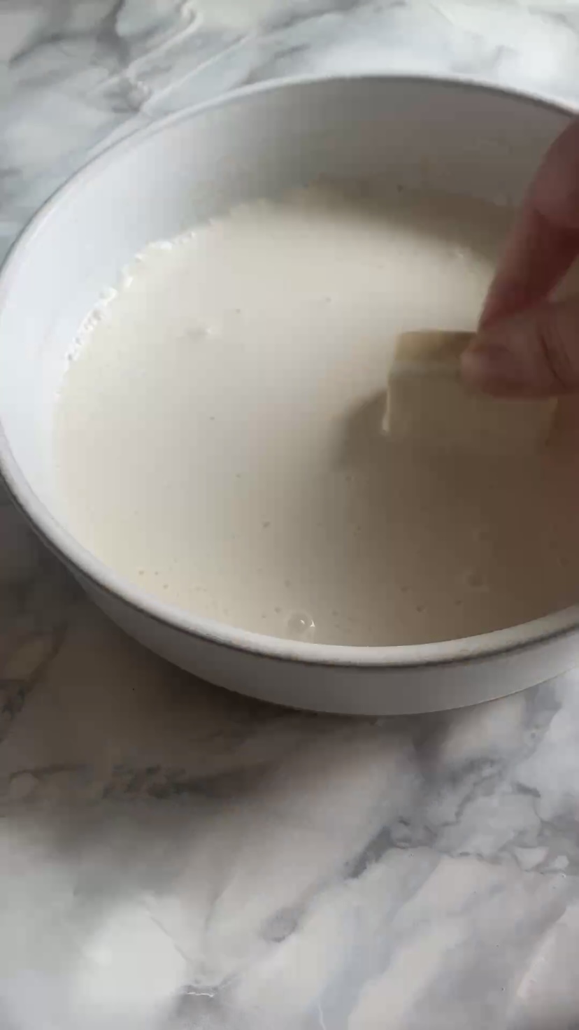 Coating the tofu in the batter.