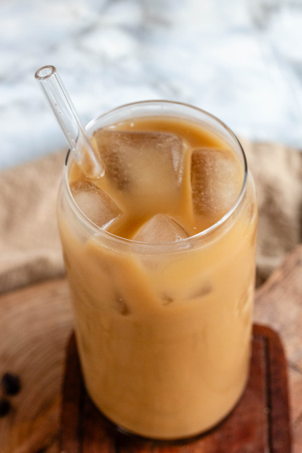 Close up of a vegan cold coffee in a glass with a straw.