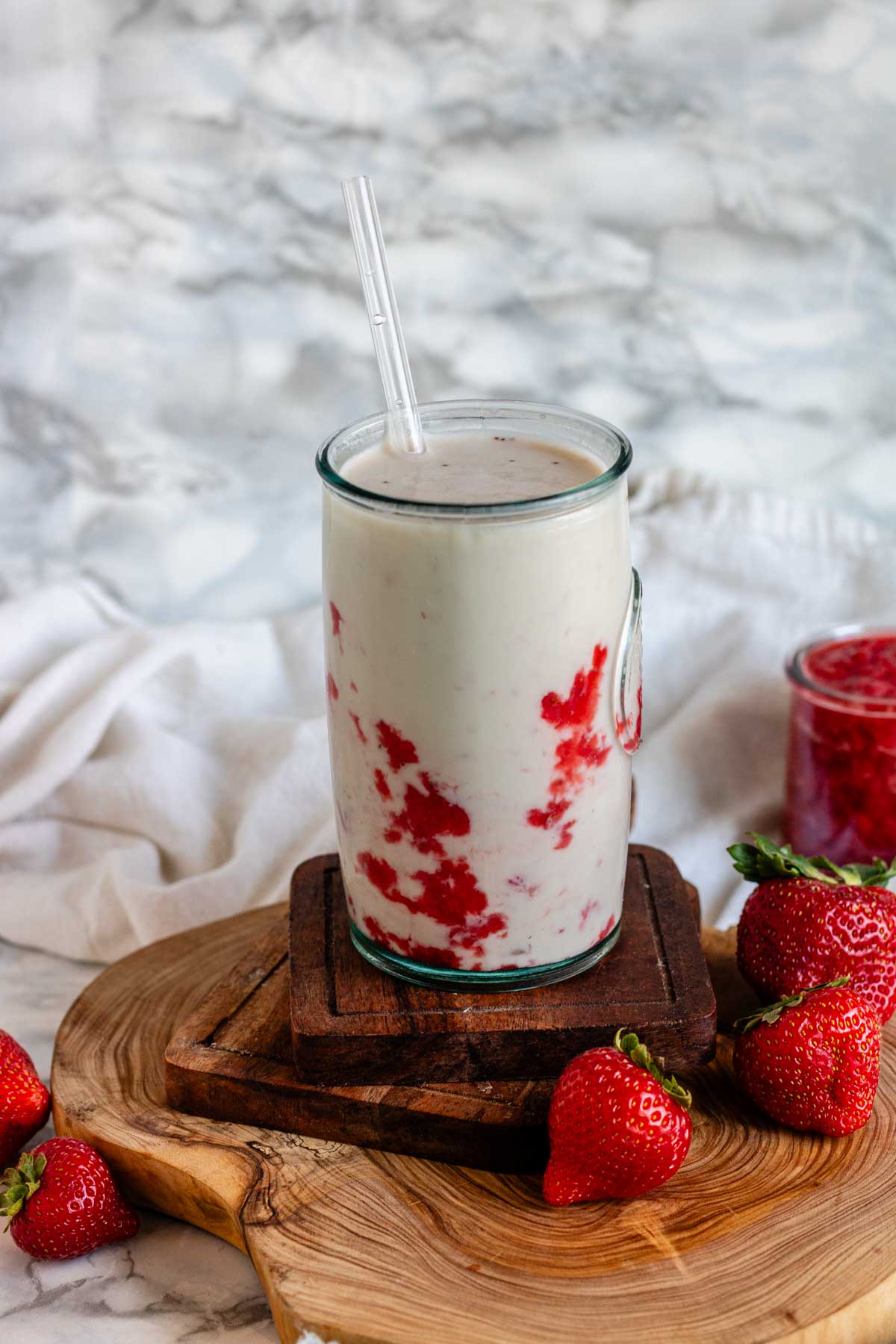 Vegan strawberry milk in a glass with straw.