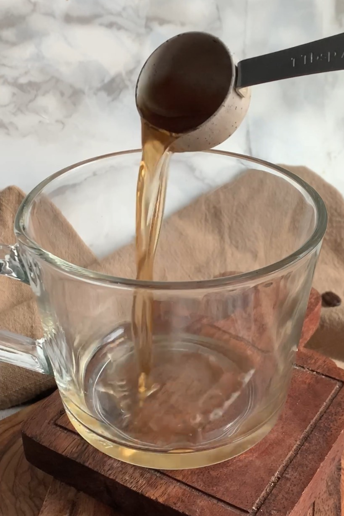 Adding vanilla syrup to a mug.