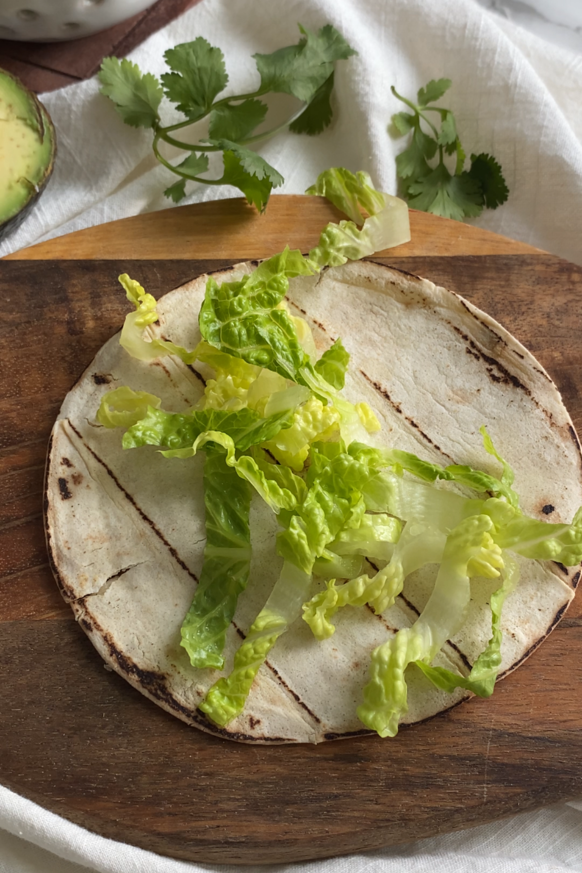 Shredded lettuce on a corn tortilla.