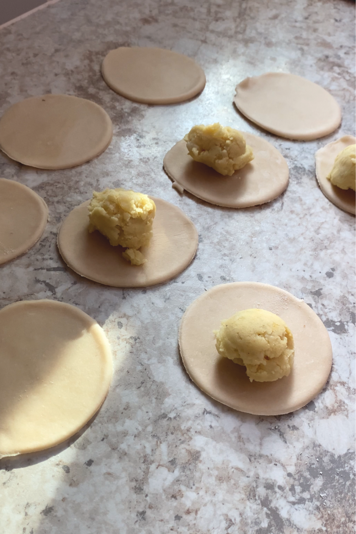 Potato filling on pierogi dough.