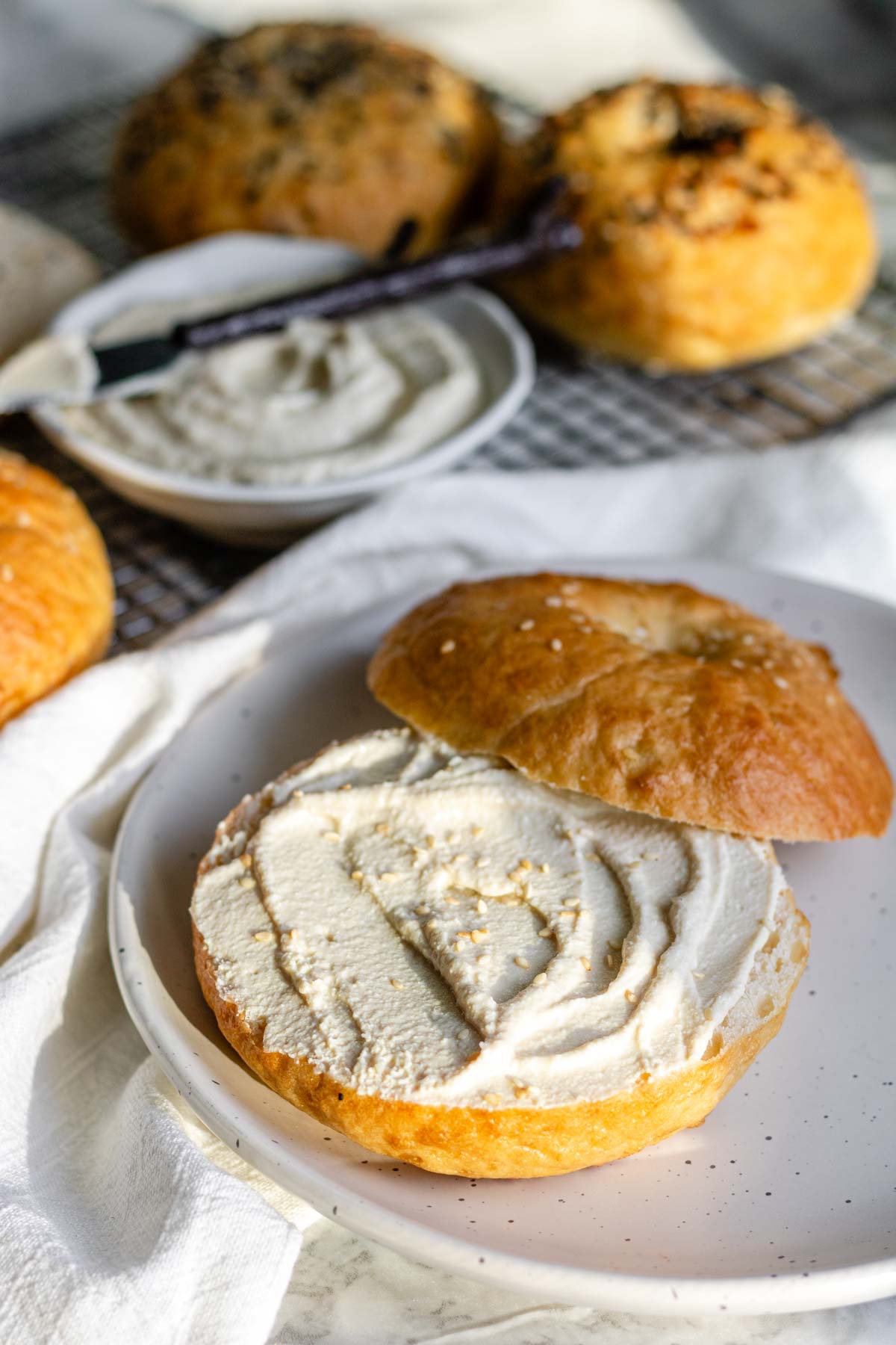 Vegan bagel with vegan cream cheese on a plate.