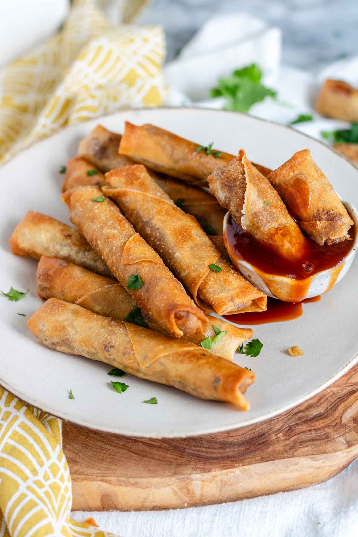 Vegan lumpia on a plate with sauce.