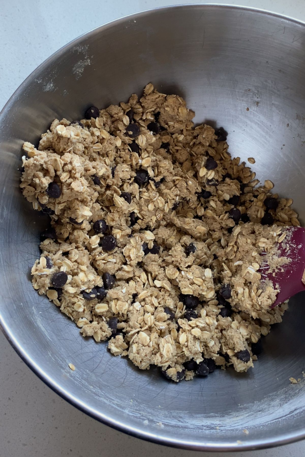 Vegan oatmeal chocolate chip cookie dough in a stainless steal bowl.