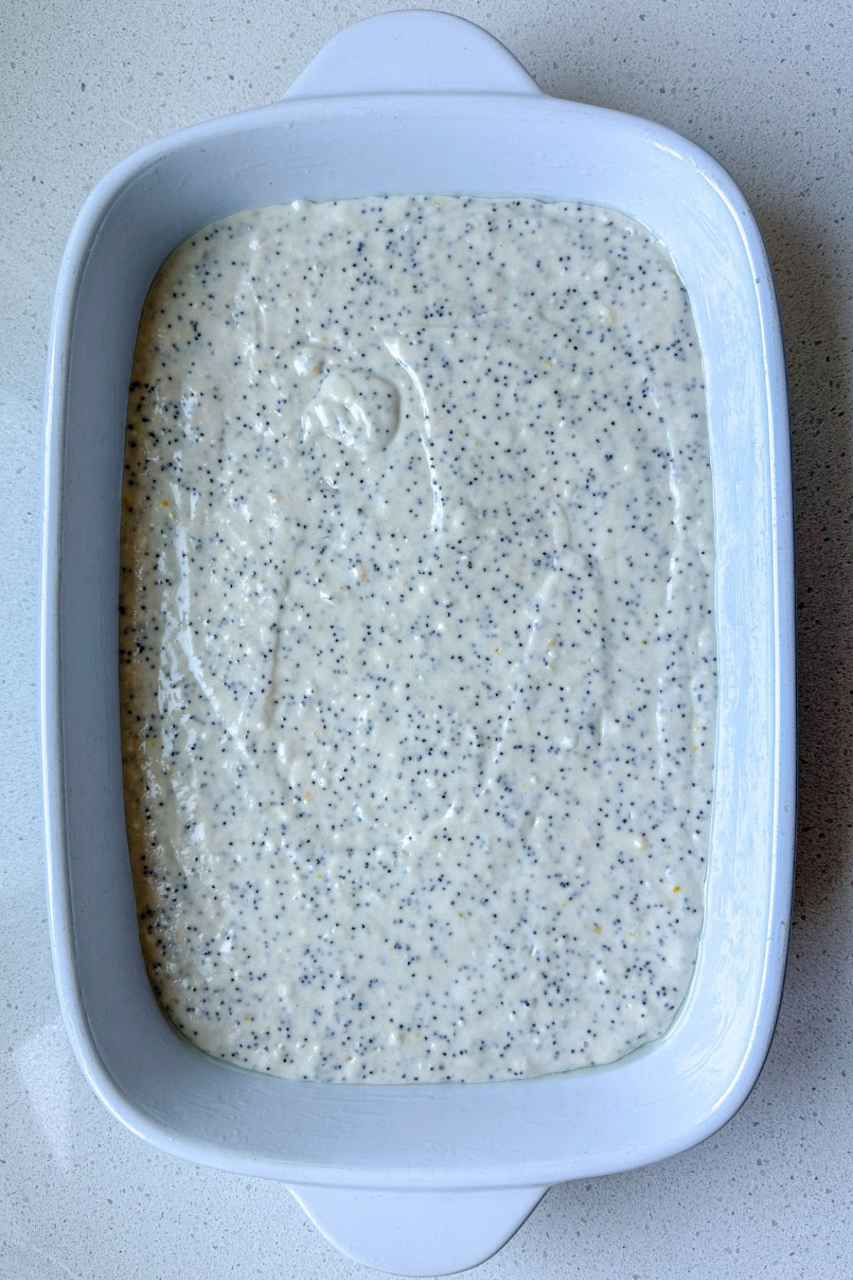 Lemon poppy seed cake batter in a baking dish.