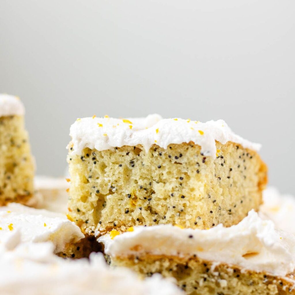 A close up of a square of frosted lemon poppy seed cake.