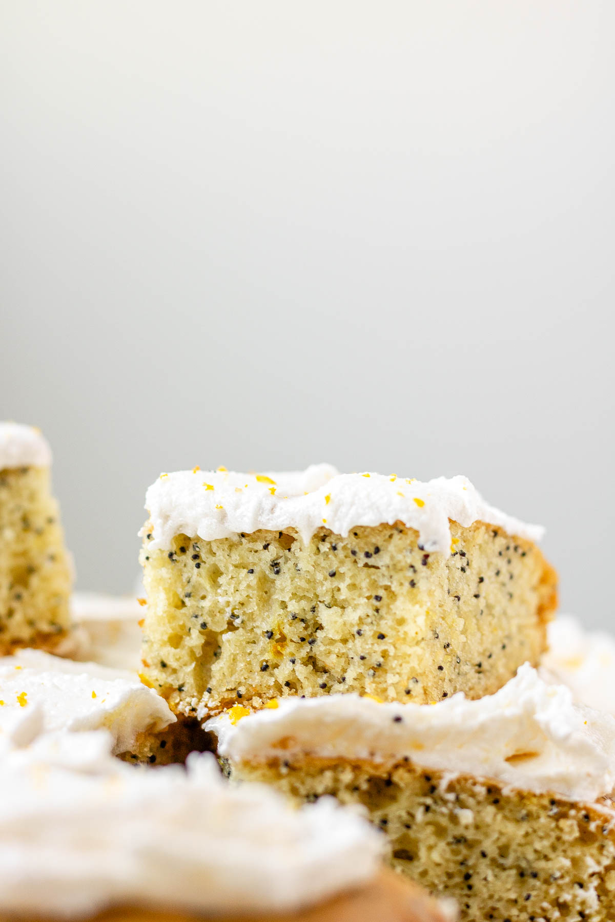 A square of frosted lemon poppy seed cake on top of the cake.
