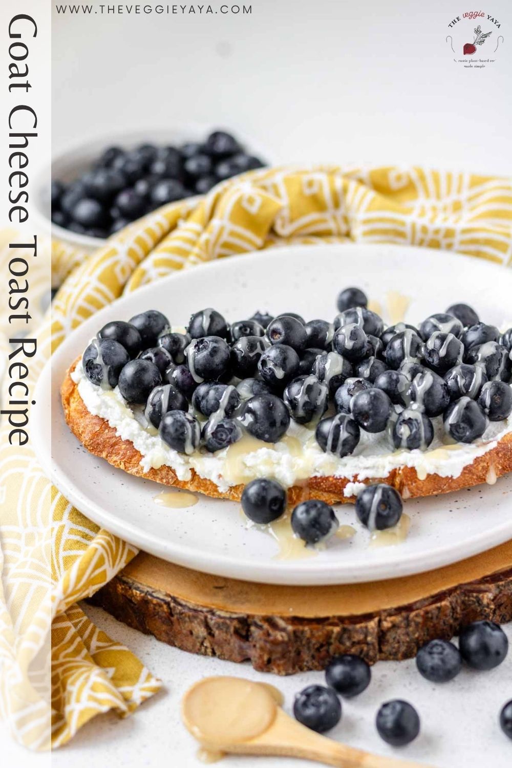 Blueberry goat cheese toast on a white plate with black text along the left side of the image.