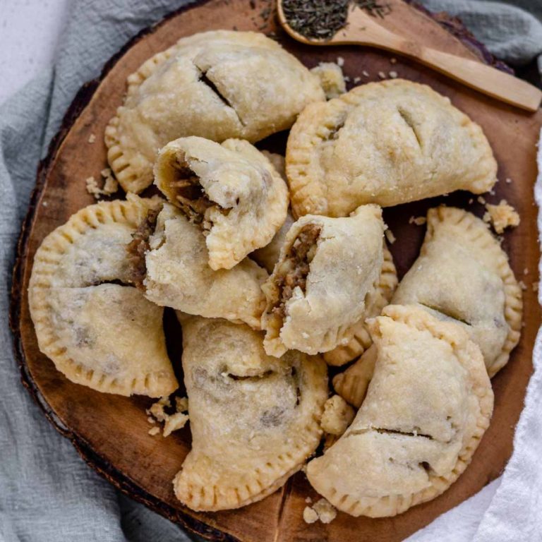 Top down view of vegan meat pies on a wooden platter.