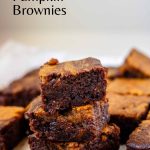 Three pumpkin brownies stacked on top of each other with black text above indicating the dish.