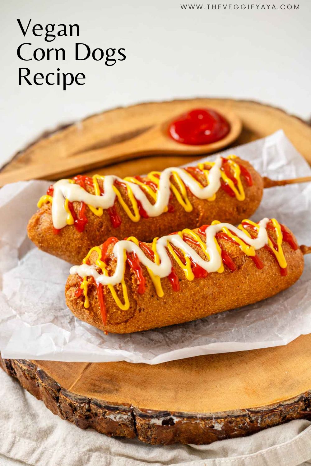 Two vegan corn dogs topped with ketchup, mustard, and vegan mayo on a wooden platter.