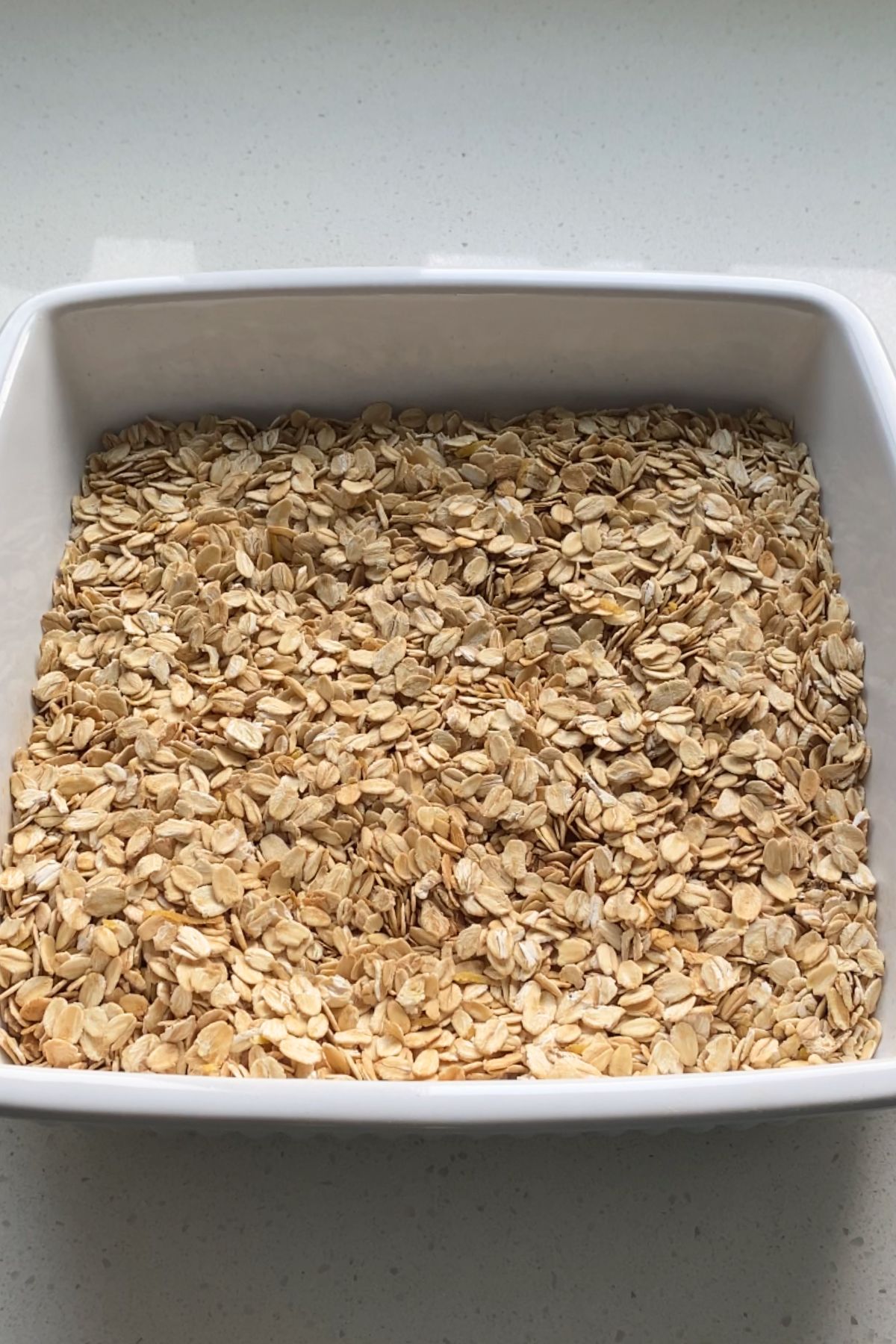 Large flake oats in a white baking dish.