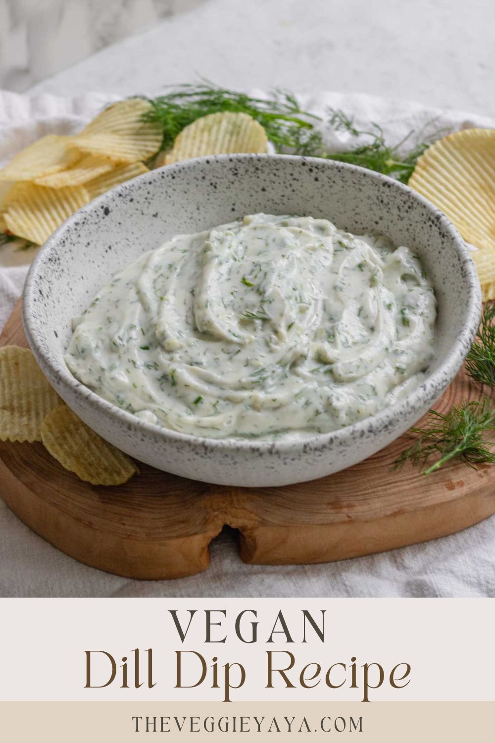 A bowl of vegan dill dip surrounded by chips with text at the bottom.