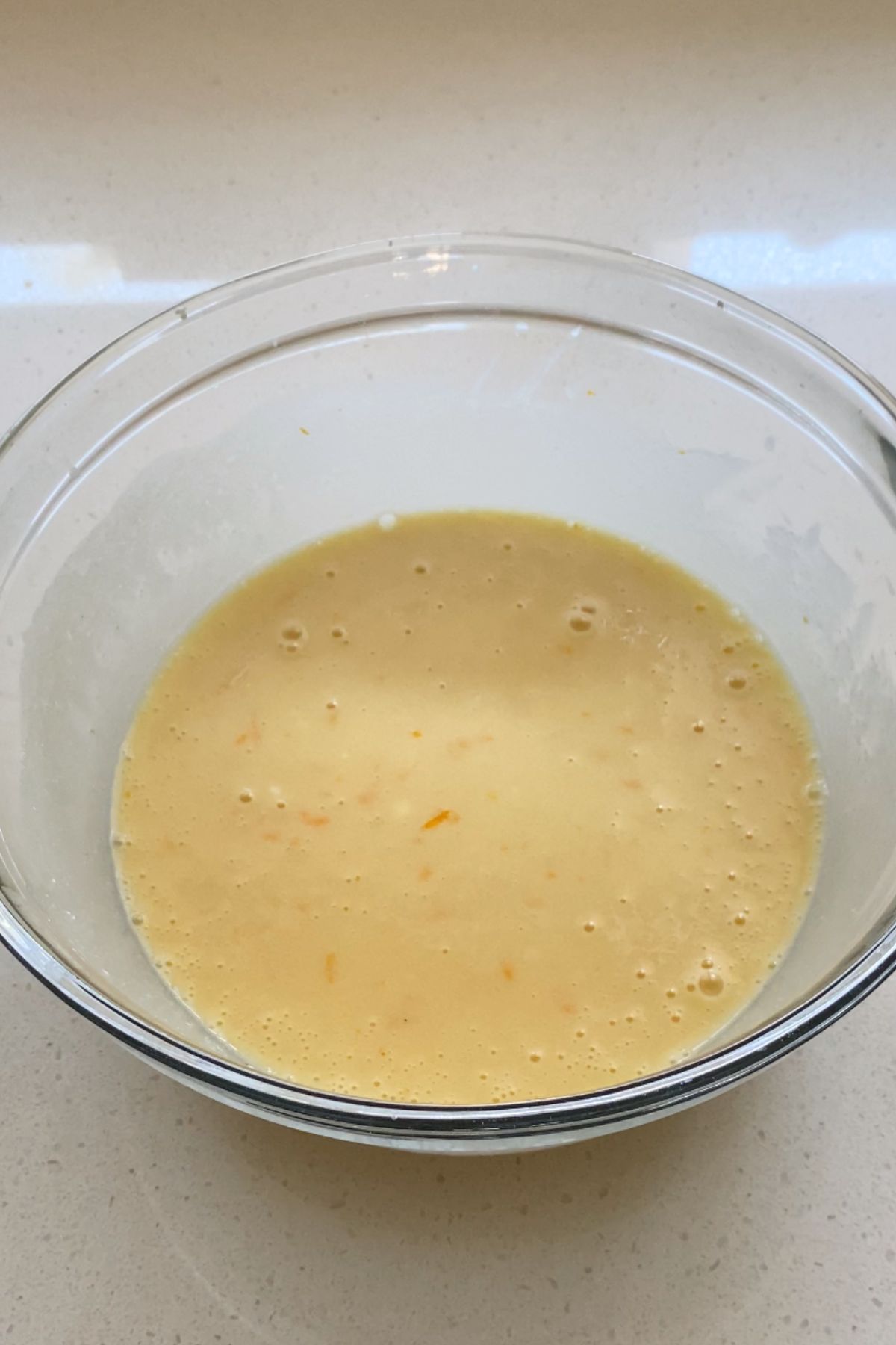 Wet ingredients for a cake batter in a glass mixing bowl.