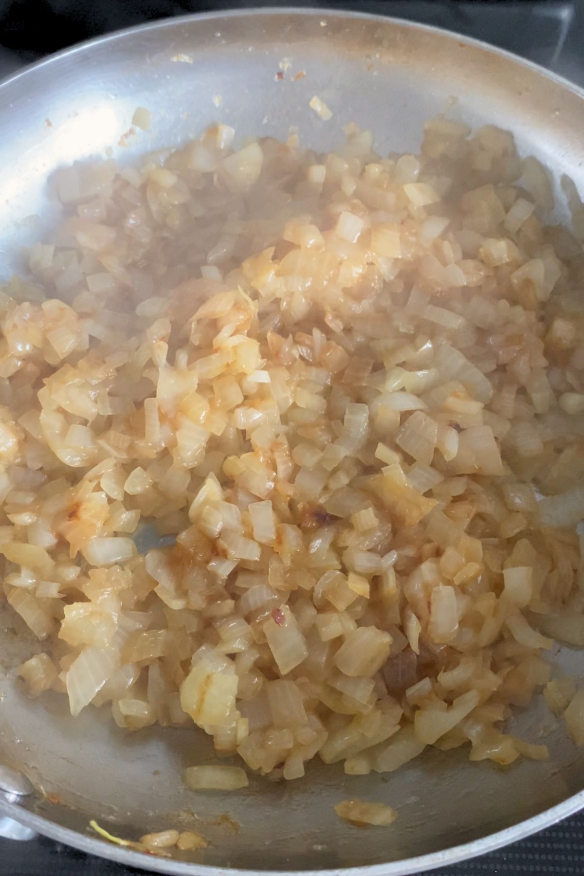 Fried onions in a stainless steel pan.