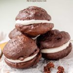 Vegan whoopie pies on a wooden platter with text above.
