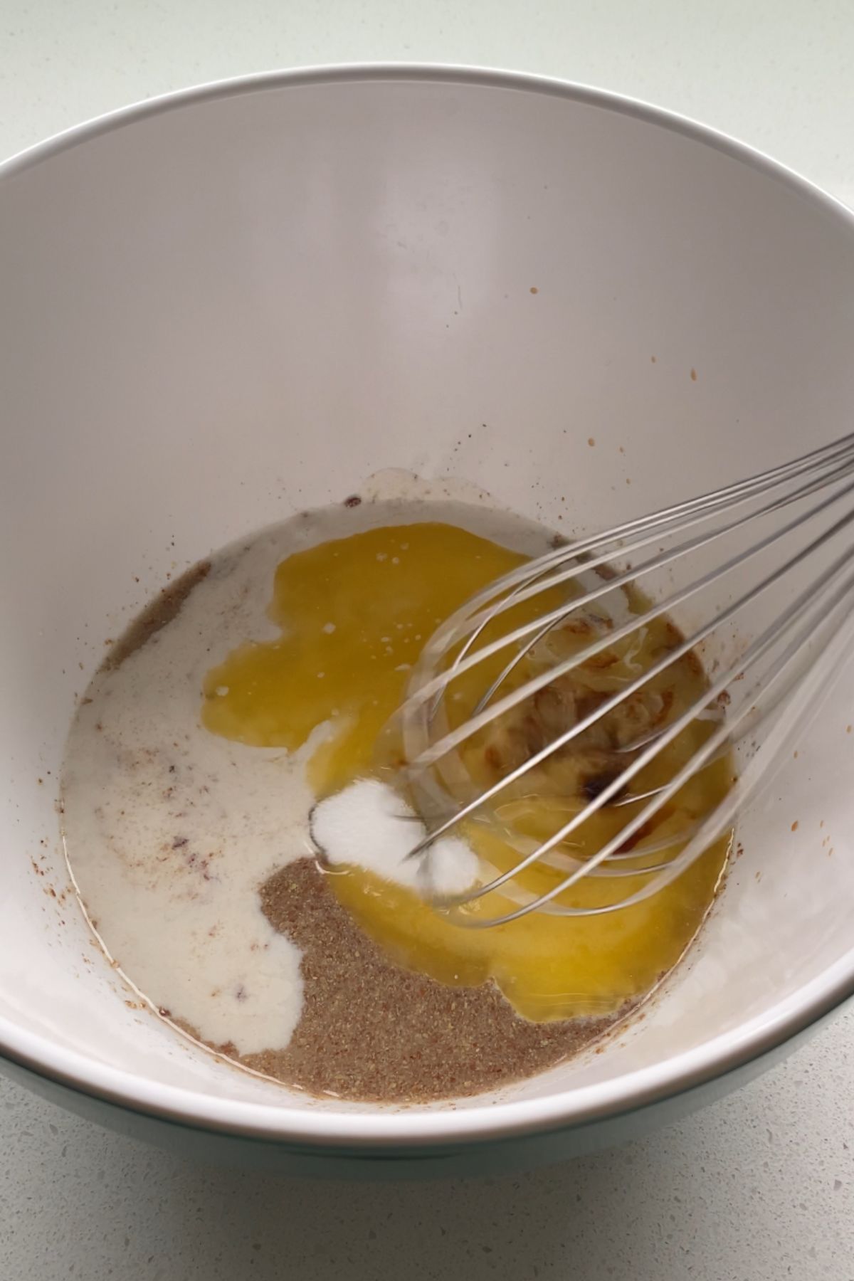 Wet ingredients for vegan whoopie pies in a mixing bowl with a whisk.