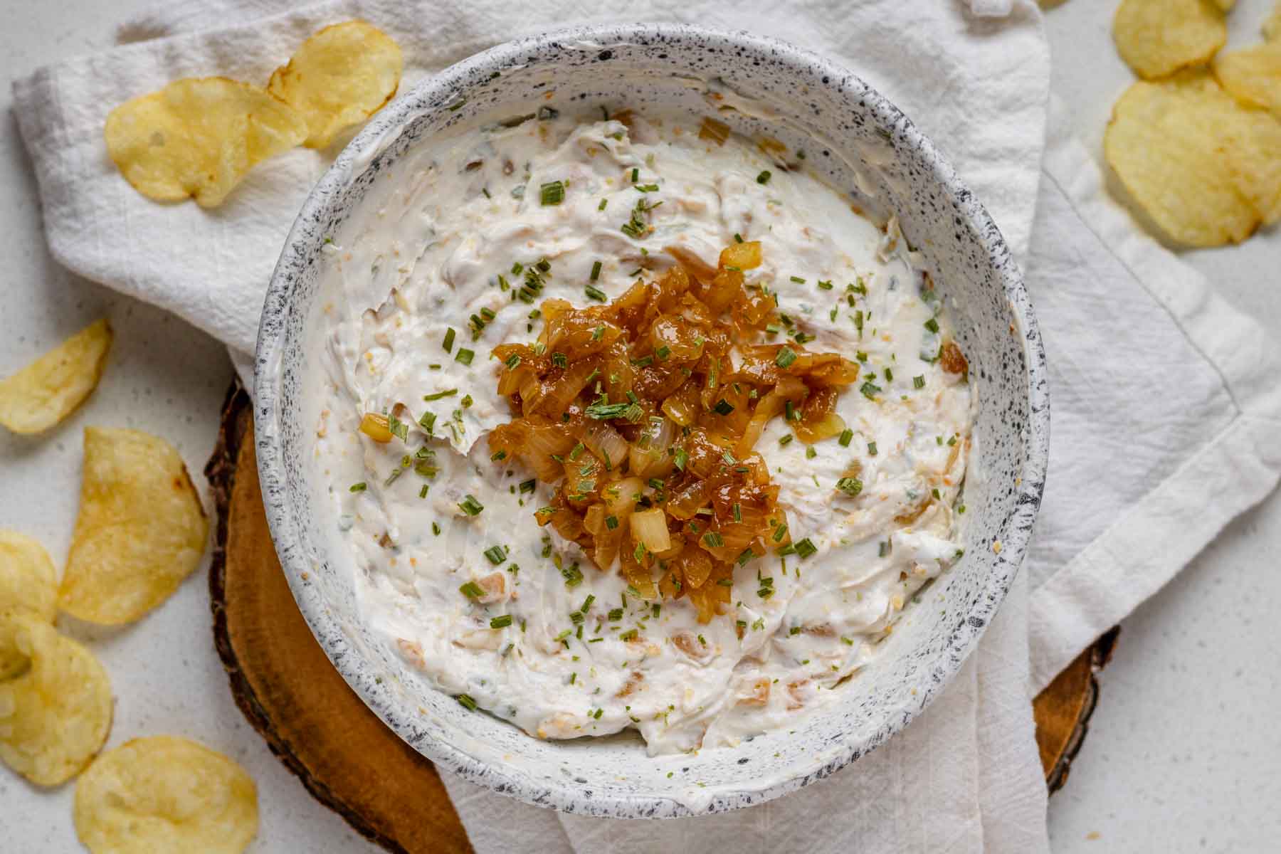 A top down view of a bowl of French onion dip topped with caramelized onions.