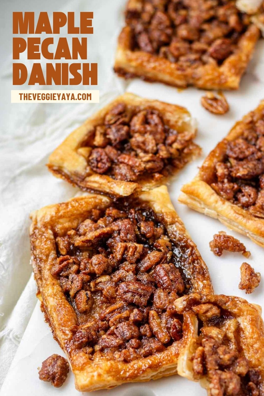 Maple pecan danishes on a white marble serving board with large orange brown text.
