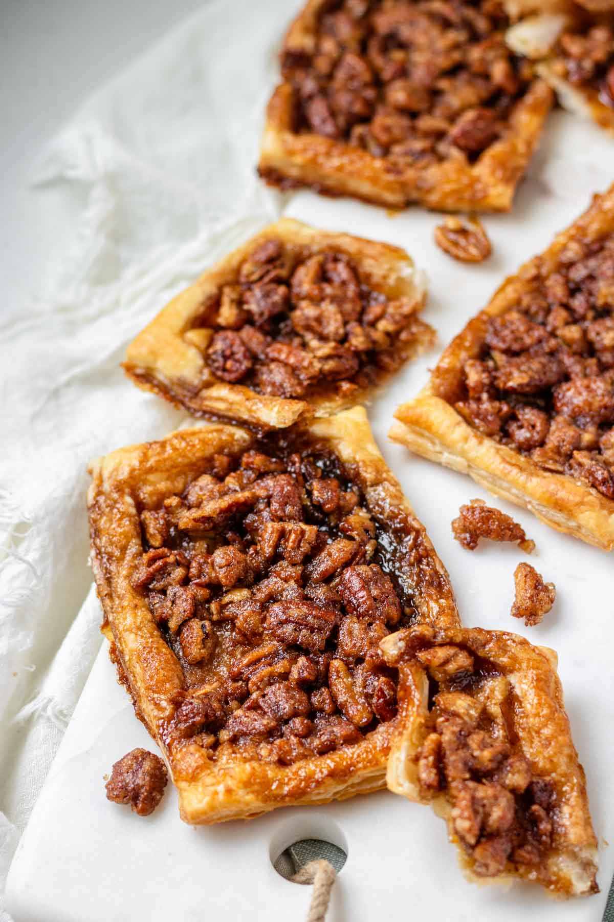 Maple pecan danishes scattered on a white marble serving board.